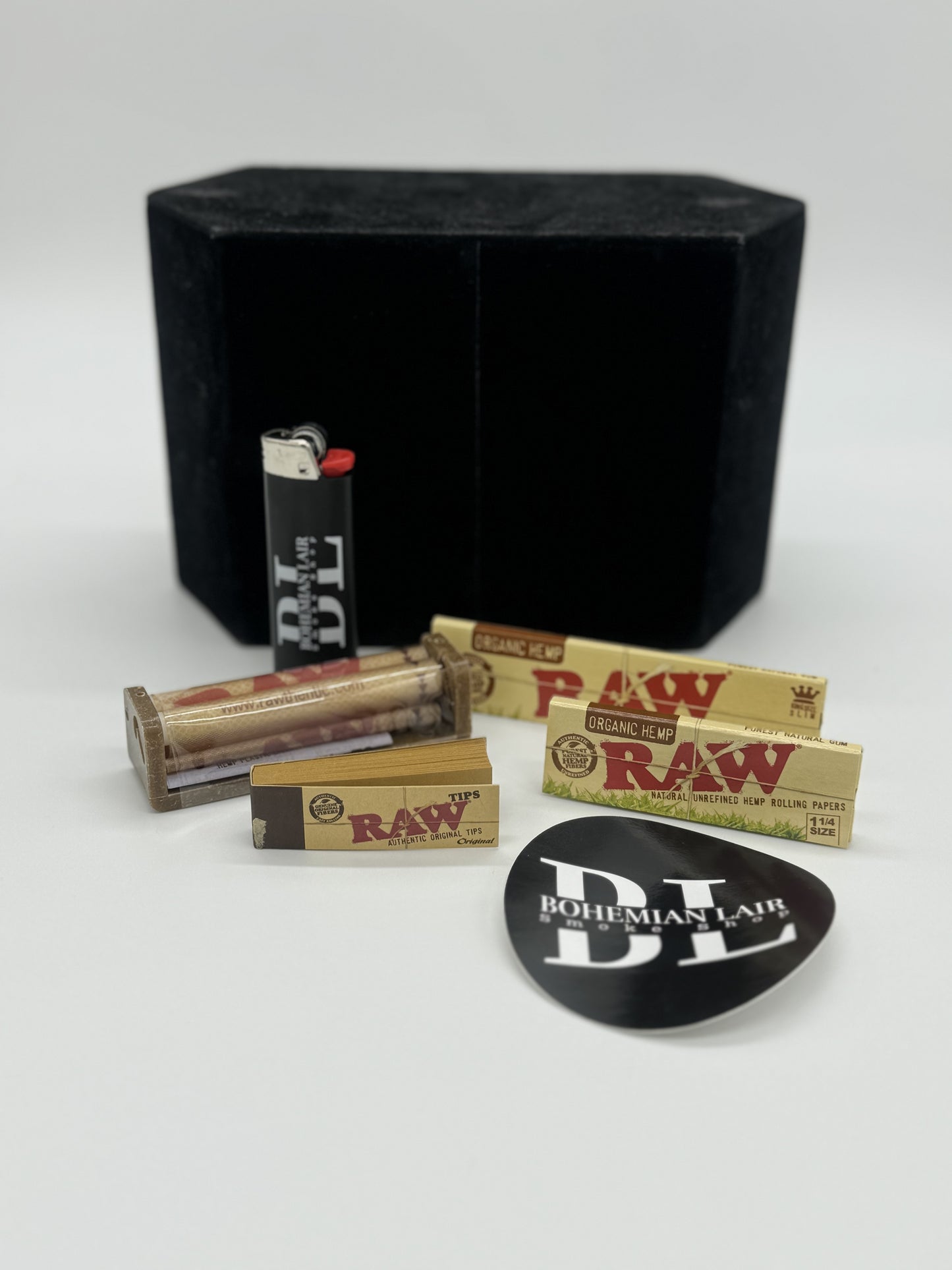 Nice Raw starter pack includes a Raw Roller, Raw Tips, Raw 1.25 and Kingsize Slim Papers, along with a Bohemian Lair Bic Lighter and a sticker from Bohemian Lair.
